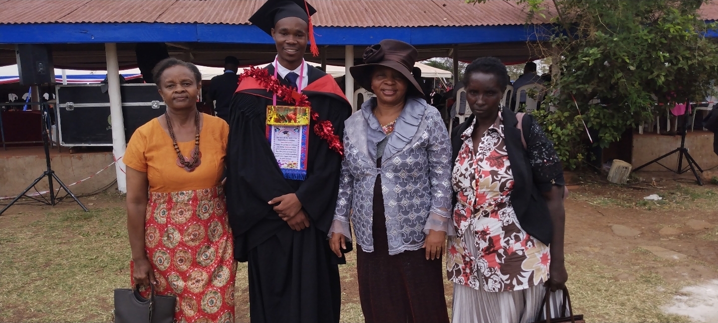 Malon Omondi in graduation cap and gown celebrating his Journalism degree from the University of Nairobi with Dr. Grace Manjau and mentors